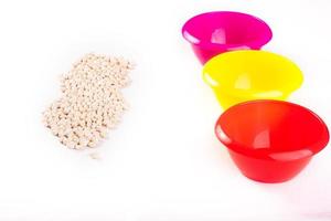 Developing lessons for young children. The development of fine motor skills. Haricot, beans and colored plastic bowl photo