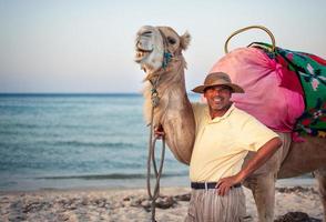 Camel owner on the coast of Tunisia with his camel, close-up photo