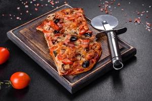 Homemade vegetable pizza with addition of tomatoes, olives and herbs photo