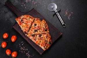 Homemade vegetable pizza with addition of tomatoes, olives and herbs photo