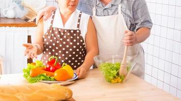 An elderly couple are helping to cook in the kitchen. photo