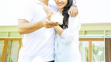 man and woman holding a house model in their hands photo