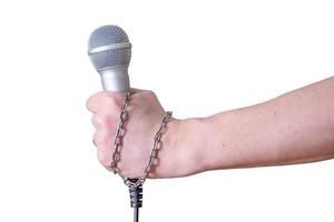 mano femenina con micrófono, sobre fondo blanco. foto