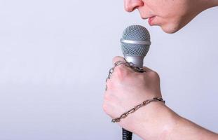 A man speaks into a microphone in close-up. photo