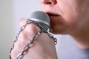 A man speaks into a microphone in close-up. photo