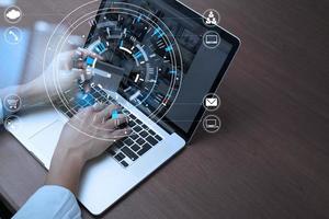 Close up of Hand using credit card and laptop computer on wooden desk with VR icon chart graph diagram photo