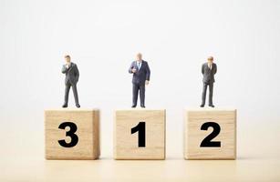 Businessman figure standing on wooden podium number 1 2 and 3 for business ranking competition concept. photo