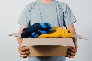 man holding a crate of second-hand clothes unused clothes photo