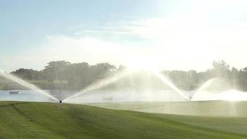 Automatic high-pressure water sprinkler at the golf course watering the grass,water spray pressure pump watering the lawn