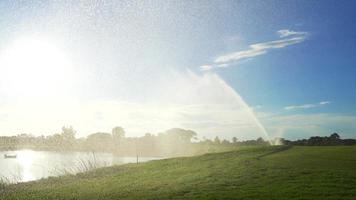 arroseur d'eau automatique à haute pression au terrain de golf arrosant l'herbe, beaucoup de brouillard arrose la pelouse. video
