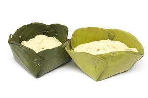 Egg custard wrapped in a banana leaf on a white background. photo