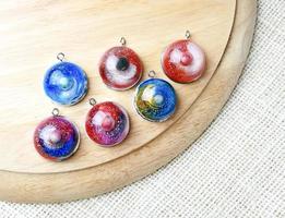 Create galaxy drink coasters using resin, glitter and pigment powders, handmade items. Suitable for keychains, necklace and pendant. photo