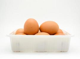 huevos, huevos marrones frescos en la caja de plástico blanca