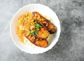 Deep fried sliced Pangasius fish with garlic, served with brown rice. photo