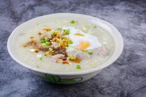 congee, gachas de arroz con cerdo picado, huevo cocido, ideal para el desayuno. foto