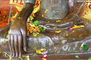 Watering Buddha statues with scented water and flower petals during Lao New Year photo