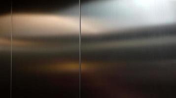 Stainless steel large sheet  With light hitting the surface  For background,Inside passenger elevator,Reflection of light on a shiny metal texture,stainless steel background. photo