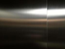 Stainless steel large sheet  With light hitting the surface  For background,Inside passenger elevator,Reflection of light on a shiny metal texture,stainless steel background. photo