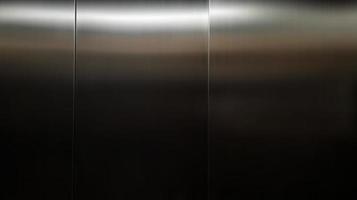 Stainless steel large sheet  With light hitting the surface  For background,Inside passenger elevator,Reflection of light on a shiny metal texture,stainless steel background. photo