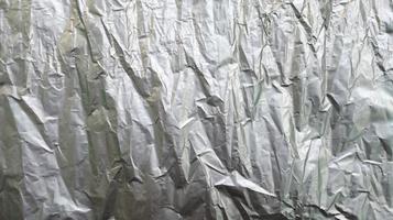 Silver foil with rough texture for background,crumpled paper, uneven surface. photo