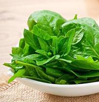 washed spinach leaves in a bowl on a wooden table photo