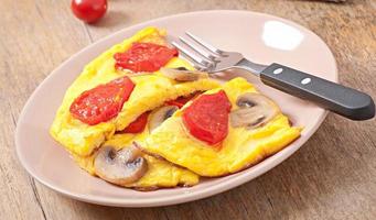 Delicious omelet with tomatoes and mushrooms for breakfast photo