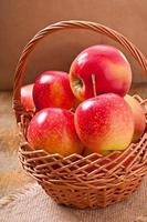manzanas en una cesta sobre fondo de madera foto