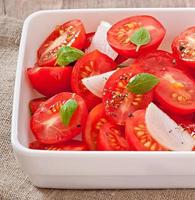 tomato cherry salad with basil, black pepper and onion photo