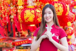 hermosa mujer asiática con cabello largo que usa un vestido rojo cheongsam foto