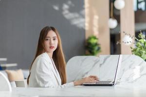 Professional business Asian woman is working seriously with computer notebook or laptop in the office. photo