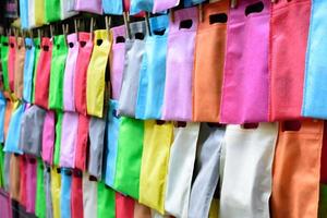 bolsas de celofán colgadas con una cuerda en la pared. fila de bolsas de colores colgando. foto