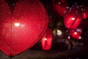 Red heart shape lamp in dark night.Photo of nightlight in the shape of a heart at the restaurant. photo