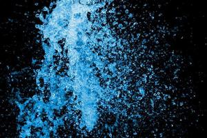 Blue water splash on the black background.  Close up Jet of water from hose use for abstract background. photo