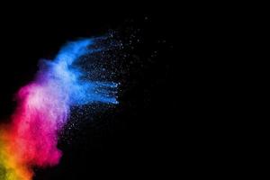 Abstract colorful powder explosion on black background.Freeze motion of dust splash.Painted Holi. photo