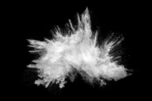 Bizarre forms of white powder explosion cloud against black background.White dust particles splash. photo