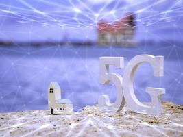 símbolo de 5g blanco con wifi y red de transmisión en la playa de piedra con cielo azul. red internet, comunicación inalámbrica y estándar 5g de concepto social de señal. foto