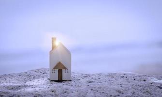 la casa blanca en miniatura sobre piedra con fondo de playa de mar. estilo de vida familiar y concepto de construcción o alquiler. foto