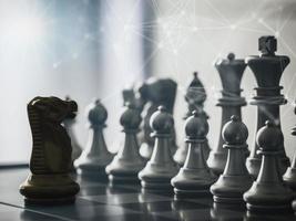Golden knight chess pieces in front off chess pieces team on chess board with technology network background to play successfully in the competition.Management or leadership strategy concept. photo