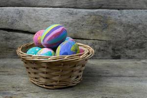 Easter eggs in the basket on wooden photo