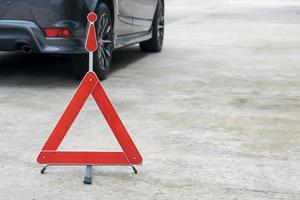 señal de coche rota en una carretera con un coche averiado foto