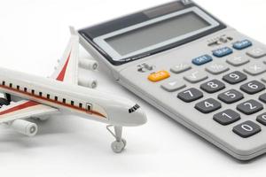 Calculadora y avión de juguete sobre fondo blanco. foto