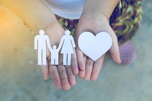 Children hands holding small model of heart and family , concept family photo