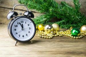 Alalrm-reloj y adornos navideños sobre fondo de madera foto