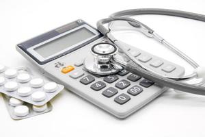 Calculator and stethoscopes on white background photo