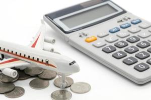 Calculator and toy plane on white background photo