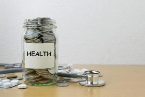 ahorro de dinero para la salud en la botella de vidrio foto