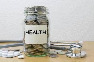 ahorro de dinero para la salud en la botella de vidrio foto