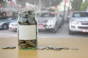 money in the glass bottle with Car showroom background blur photo