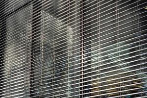 Closeup shot of metal blinds on a building from the outside on a sunny day photo