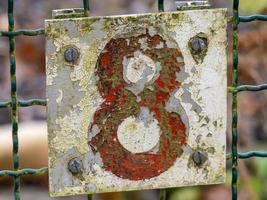 ouse number eight on sign on fence photo